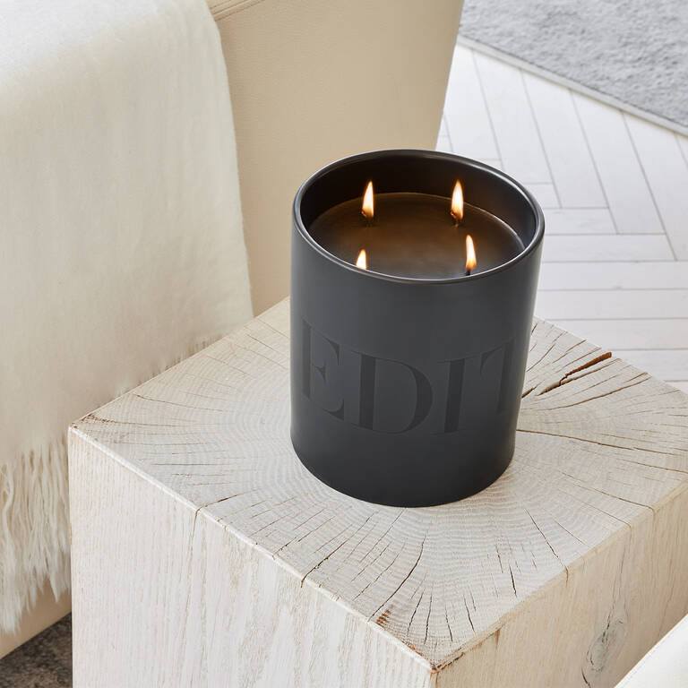 EDITION candle with woody fragrance on wood end table