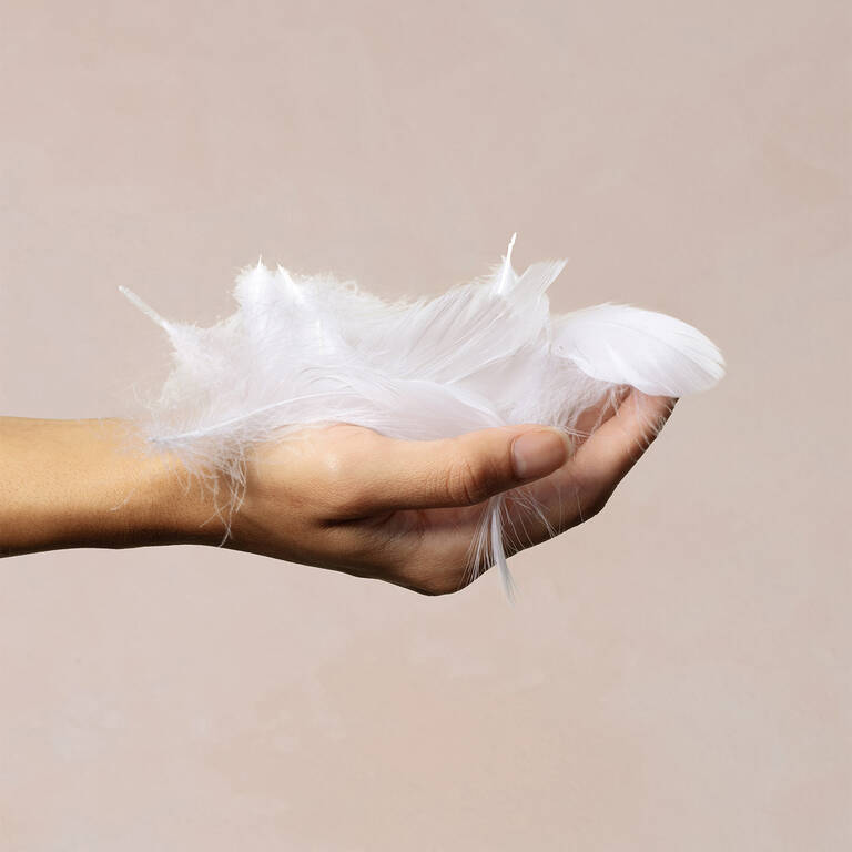 Woman's hand pulling on Marriott Bonvoy Boutiques duvet feather filling