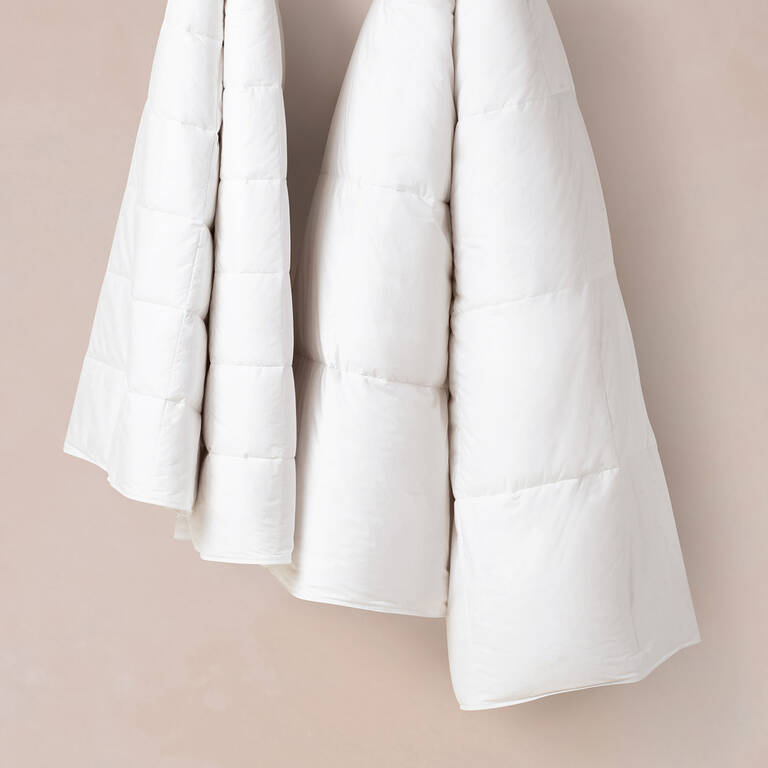 Woman's hand pulling on Marriott Bonvoy Boutiques white sheets
