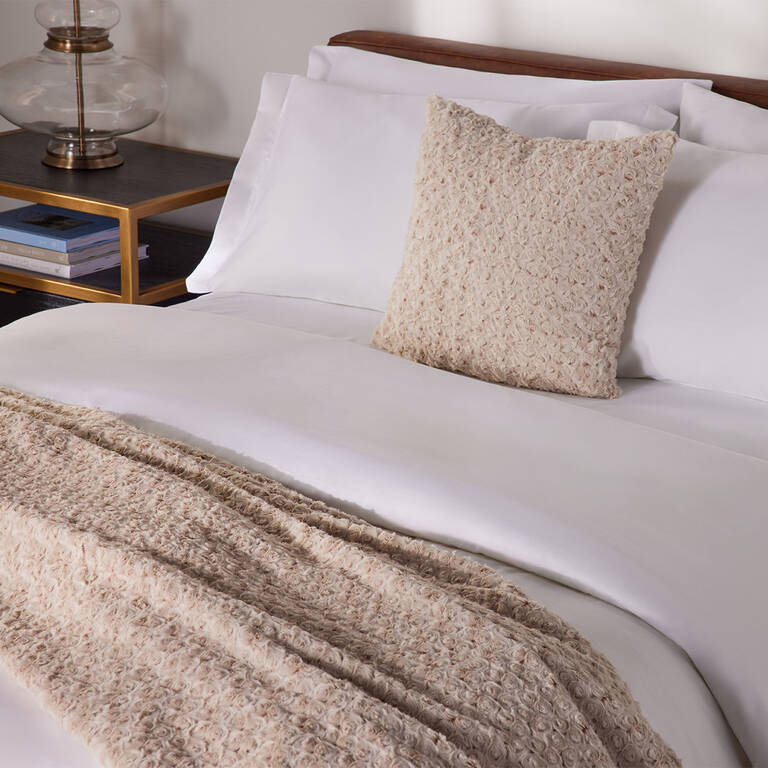 The Ritz-Carlton rosebud throw on top of made bed The Ritz-Carlton rosebud throw on top of made bed