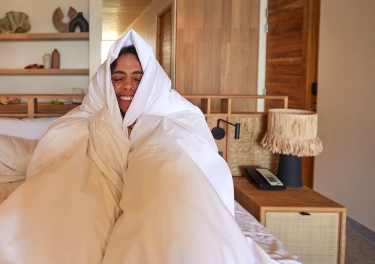 Woman wrapped in comforter on W Hotels Bed Woman wrapped in comforter on W Hotels Bed