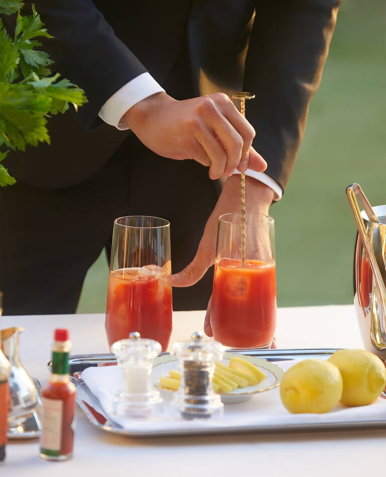 Man mixing cocktails from St. Regis Bloody Mary recipe book Man mixing cocktails from St. Regis Bloody Mary recipe book