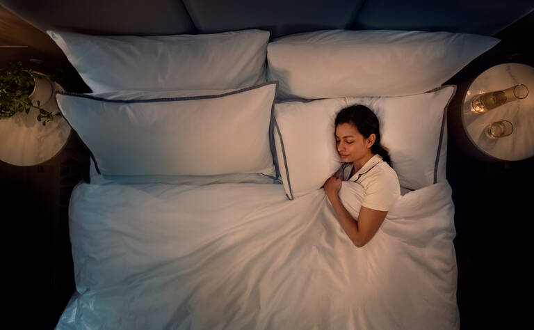 Woman sleeping in Westin Hotels Sleep Well Heavenly Bed nighttime