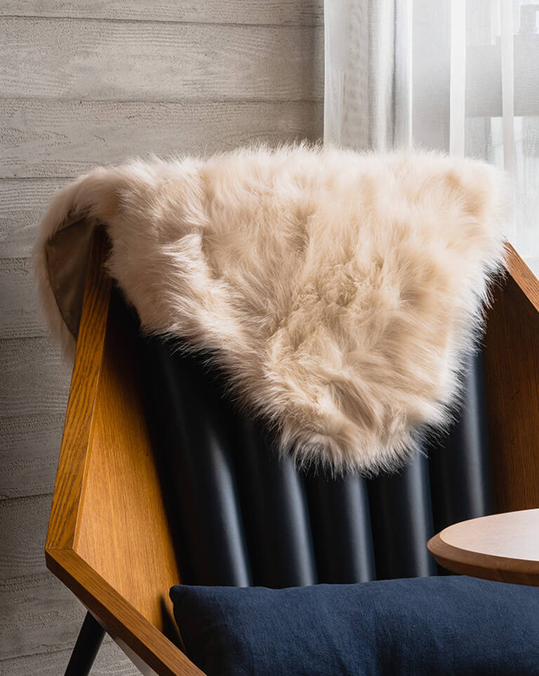 EDITION signature throw blanket hung on chair