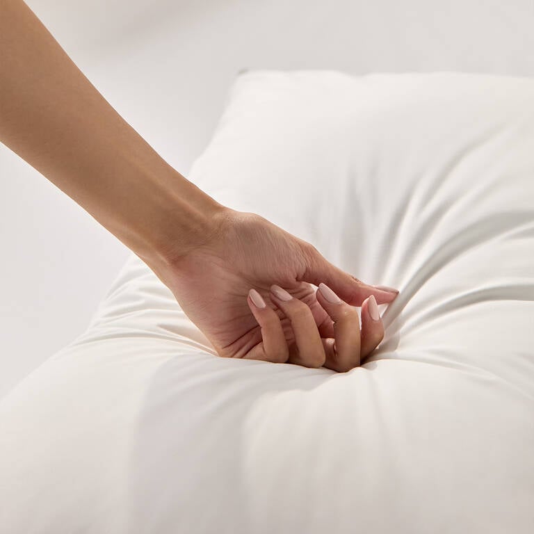 Woman pressing down on Marriott Bonvoy Boutiques pillow to showcase firmness Woman pressing down on Marriott Bonvoy Boutiques pillow to showcase firmness