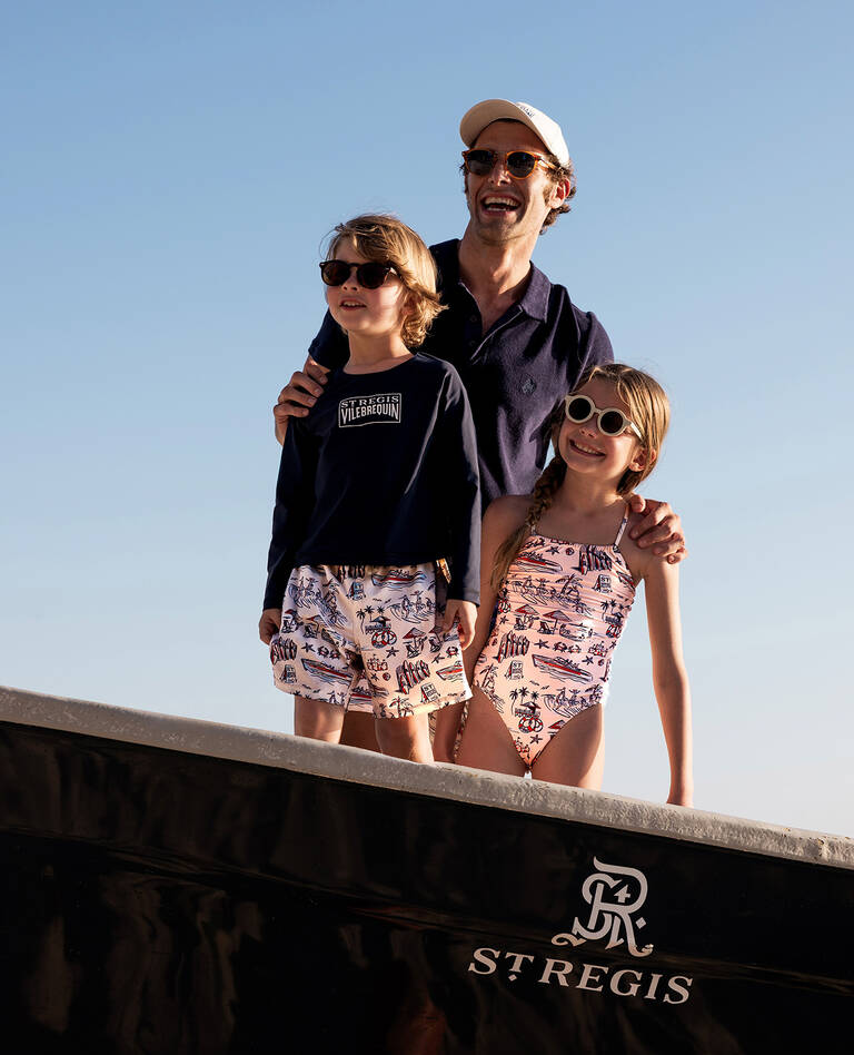 Father with two kids wearing matching St. Regis x Vilbrequin Capsule Collection beachwear