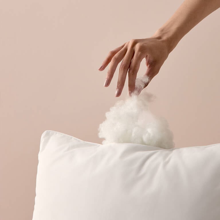 Woman pulling filling out of Marriott Bonvoy Boutiques pillow Woman pulling filling out of Marriott Bonvoy Boutiques pillow