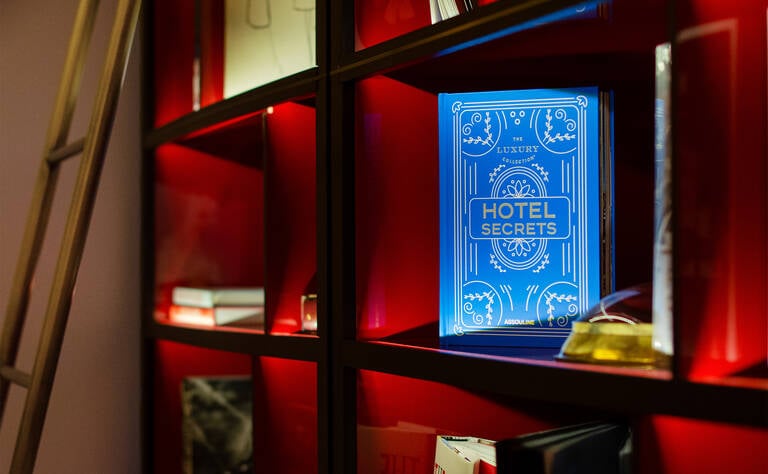 The Luxury Collection x Assouline Books "Hotel Secrets" book on shelf